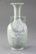 A Chinese celadon ground bottle vase, 19th century, decorated in white slip with flowers and foliage