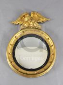 A Regency giltwood and ebonised circular convex mirror, with reeded slip and with sphere applied