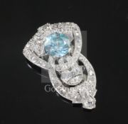 An Art Deco platinum?, blue zircon, rose and round cut diamond set lapel clip, of pierced, scrolling