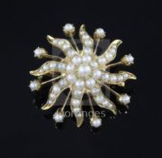 An Edwardian gold and graduated split pearl swirl sunburst pendant brooch, 31mm.