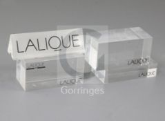 A Lalique perspex display case label and four block base labels, 9.75cm and 8cm.