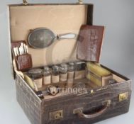 A late Victorian Edwards & Sons crocodile skin travelling toilet case containing assorted silver and