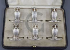 An Edwardian cased set of six novelty silver owl menu holders, by Sampson Morden & Co, with glass