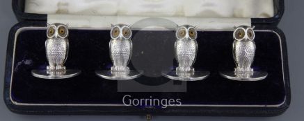 A matched cased set of four Edwardian novelty silver owl menu holders, with glass eyes, Goldsmiths &