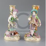 A pair of Minton candlestick figures, c.1835-36, modelled as male and female flower sellers, with