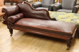 An early Victorian mahogany framed chaise longue, on reeded turned and tapering legs with brass feet