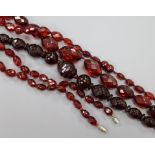Three single strand facetted simulated cherry amber necklaces.