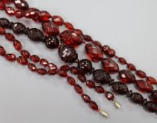 Three single strand facetted simulated cherry amber necklaces.