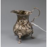 A George III silver cream jug with later embossed decoration.