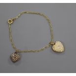 A French 18ct yellow metal bracelet, hung with two yellow metal and seed pearl set heart shaped