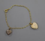 A French 18ct yellow metal bracelet, hung with two yellow metal and seed pearl set heart shaped