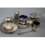 A silver butter shell, silver napkin rings and other items including silver condiments.