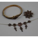 An early 20th century garnet set necklace, brooch and hinged bangle.