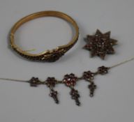 An early 20th century garnet set necklace, brooch and hinged bangle.