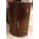 A late 18th century mahogany bow fronted hanging corner cupboard W.65cm