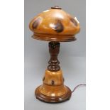 A fruitwood lamp, on circular foot, with vari baluster stem and domed wood shade, overall height