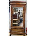 A Charles X mahogany wardrobe, with moulded cornice, fitted mirror panelled door and base drawer, on