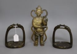 A Chinese bronze figure of a boy and a pair of early Chinese bronze stirrups