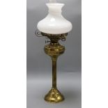 A Victorian brass reeded column oil lamp, on circular foot, with compressed spherical reservoir