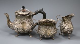 A late Victorian emobssed silver three piece tea set, gross 18 oz.