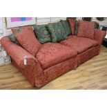 A large two seater settee, with a red and pink brocade loose cover W260cm