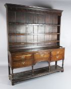 A George III oak dresser, with three shelf rack and five long drawers over a pot board, W.6ft 3in.