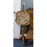 A Victorian maple pole firescreen, with adjustable brass tubular stem on reeded tripod base,