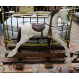 A Victorian-style rocking horse with leather saddle on mahogany safety frame L.135cm