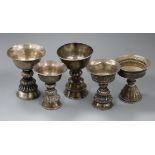 Five 19th century Tibetan white metal yak butter lamps.