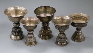 Five 19th century Tibetan white metal yak butter lamps.