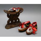 A pair of beaded North American Indian childs moccasins, a similar miniature pair and a tribal