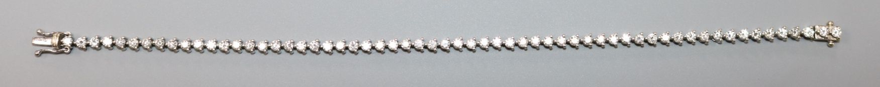 A modern 18ct white gold and diamond line bracelet, the fifty eight diamonds with a total weight