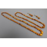 Two amber bead necklaces and a pair of amber earrings, gross weight 52 grams.