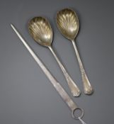 A modern silver meat skewer and a pair of silver serving spoons.