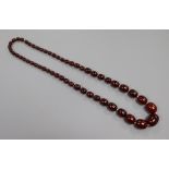 A single strand simulated cherry amber necklace, gross 76 grams, 72cm.