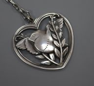 A Danish Georg Jensen sterling silver heart shaped bird brooch, no. 97, on a white metal chain,
