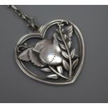 A Danish Georg Jensen sterling silver heart shaped bird brooch, no. 97, on a white metal chain,