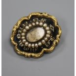 An early Victorian yellow metal, black enamel and seed pearl set mourning brooch, 26mm.