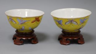 A pair of Chinese Tongzhi yellow ground butterfly bowls, wood stands diameter 11cm