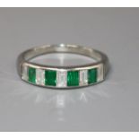 A modern white metal and nine stone emerald and diamond set half eternity ring, set with emerald and