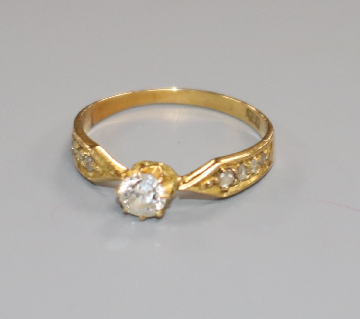 An early 20th century 18ct gold and single stone diamond ring, with diamond set shoulders, size K.