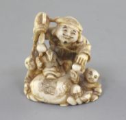 An ivory netsuke of Daikoku and two boys, Meiji period, Daikoku holding his mallet, with his foot