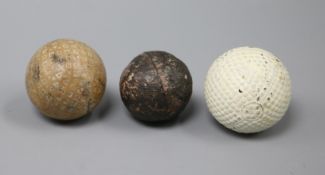 A white colonel dimple pattern golf ball and two other vintage golf balls