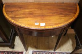 A George III mahogany and tulipwood banded 'D' shape card table W.91cm