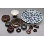 A Chinese underglaze blue and copper red dish, a bowl and various wood stands