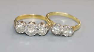 An 18ct gold and two stone illusion set diamond ring and a yellow metal and three stone illusion set