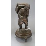 A Japanese spelter group of an elderly man carrying a large chest height 28cm