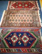 A Bokhara style mat and two others 116 x 66cm, 130 x 81cm and 125 x 65cm