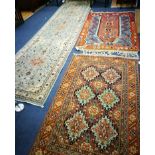 A Persian burnt orange ground rug, centred by six pale green lozenges and two other rugs,