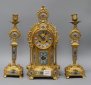 A late 19th century French three piece gilt spelter and champléve clock garniture, the eight day